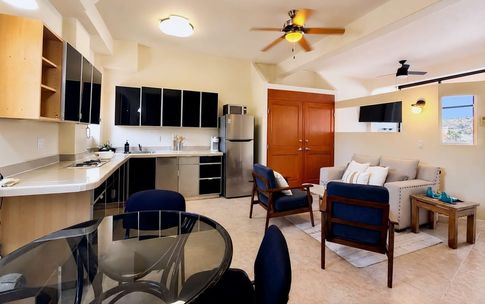 Fully equipped kitchen, living space, and a ceiling fan.