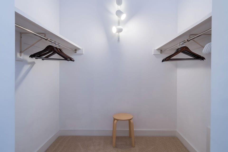Ample closet space with dual hanging rods and modern lighting ensures your wardrobe stays organized throughout your stay.