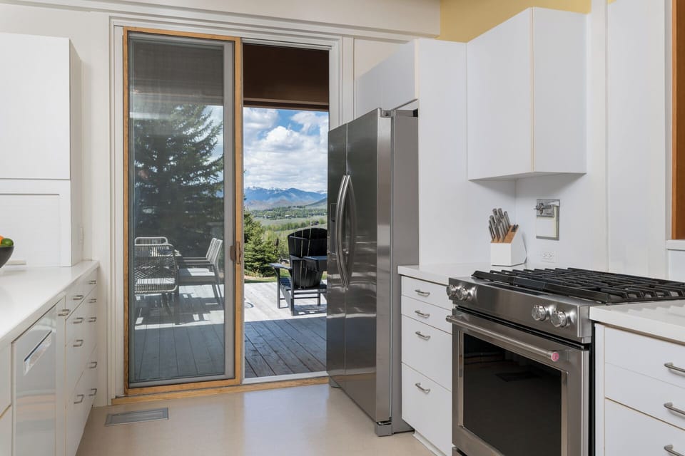 Your bright, modern kitchen opens to a private deck with breathtaking mountain views—perfect for morning coffee or prepping meals while soaking in the scenery.