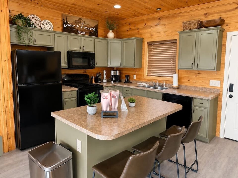 Fully equipped Gatlinburg cabin kitchen with island seating, popcorn area, coffee station, and cozy mountain cabin style.