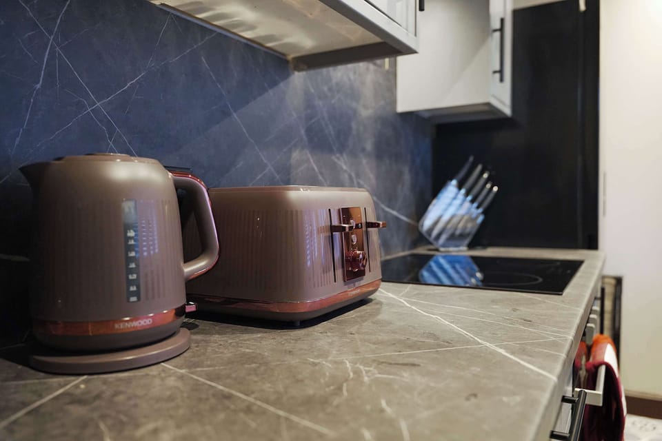 A practical kitchen space featuring useful worktops, a kettle, and everyday preparation areas for a convenient stay. The simple setup provides guests with a comfortable environment for making drinks and preparing meals.
