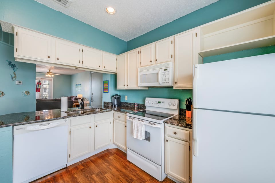 Well-appointed kitchen featuring ample cabinet space, granite countertops, and everything you need to cook breakfast, lunch, or dinner during your stay.