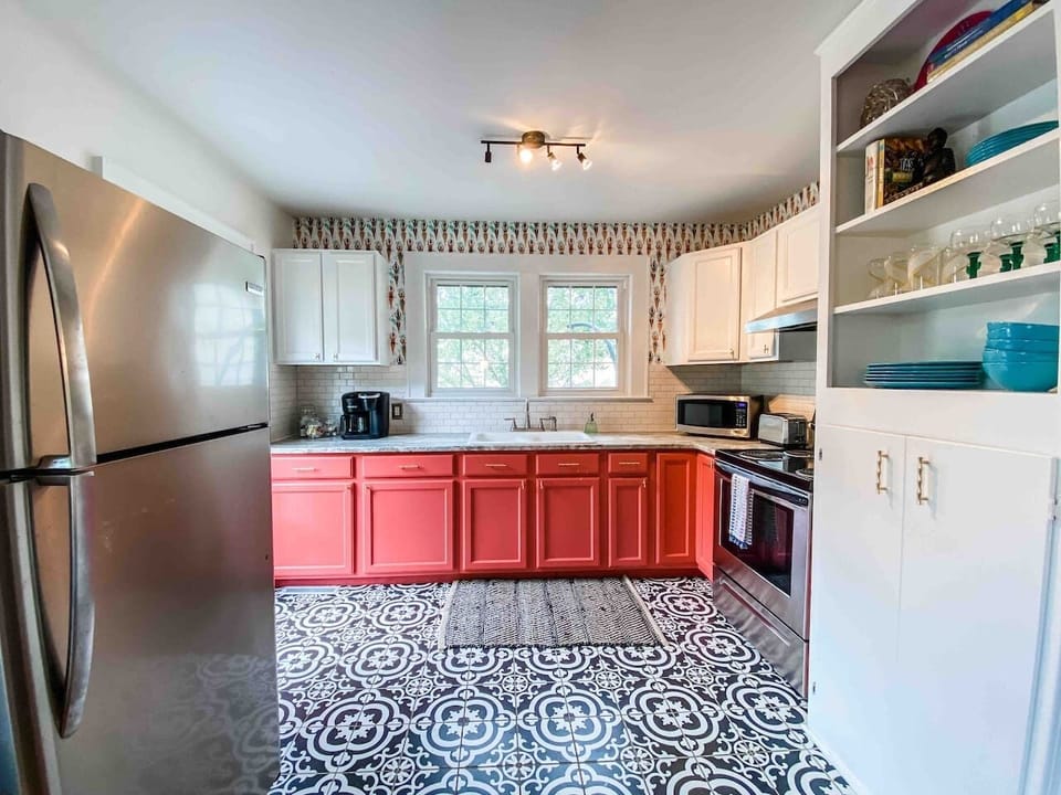 A fully equipped kitchen with stainless steel appliances, toaster, microwave, blender and coffee maker.