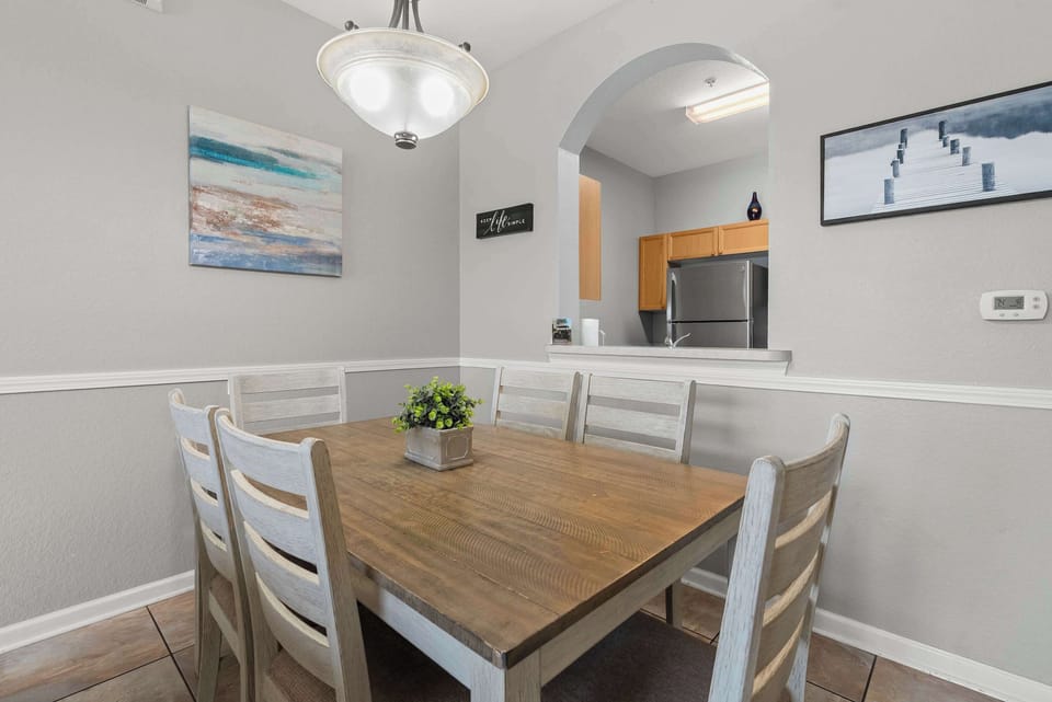 Dining area with rustic wooden table and open kitchen pass-through for easy serving.