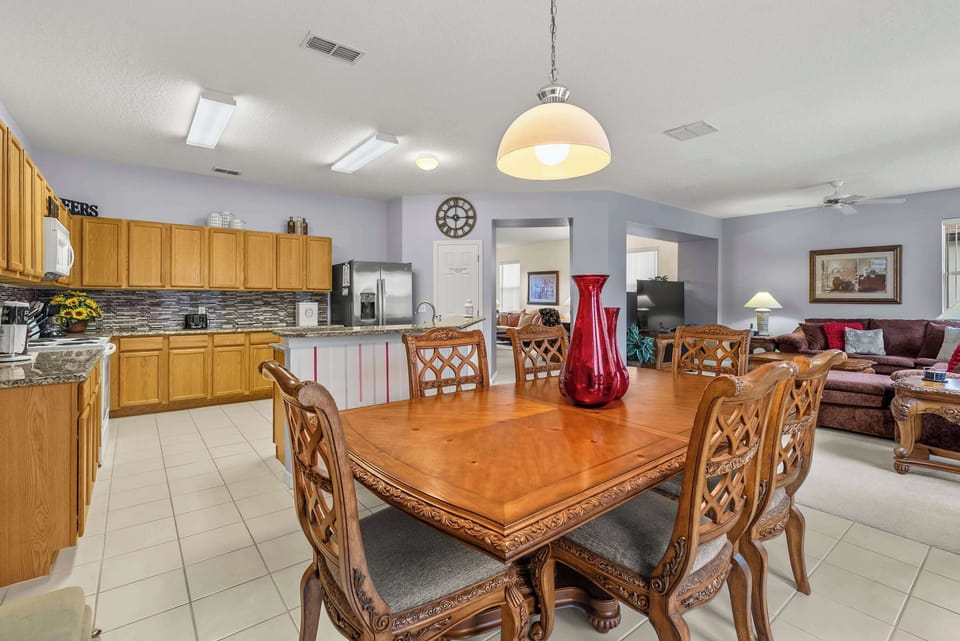 Spacious dining area with classic wooden furniture adjacent to a fully equipped kitchen.
