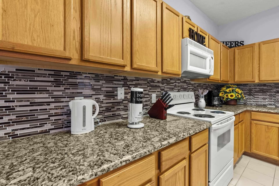 Kitchen with granite countertops, oak cabinets, and a tiled backsplash for a modern look.