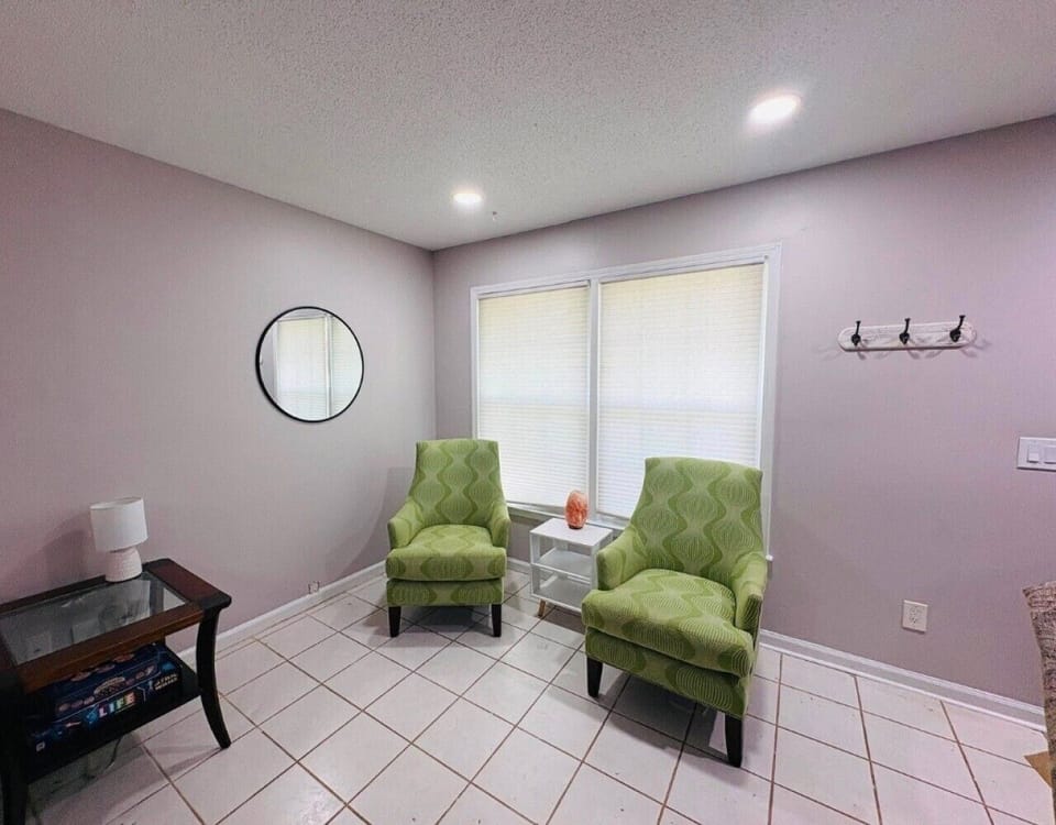 A cozy conversation corner featuring stylish green accent chairs—perfect for morning coffee or catching up on a book.