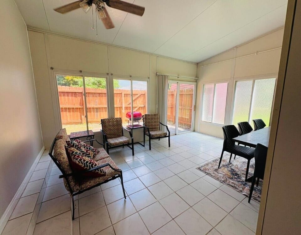 A spacious, sun-drenched sunroom featuring bright dining area perfect for meals, morning coffee, or remote work.
