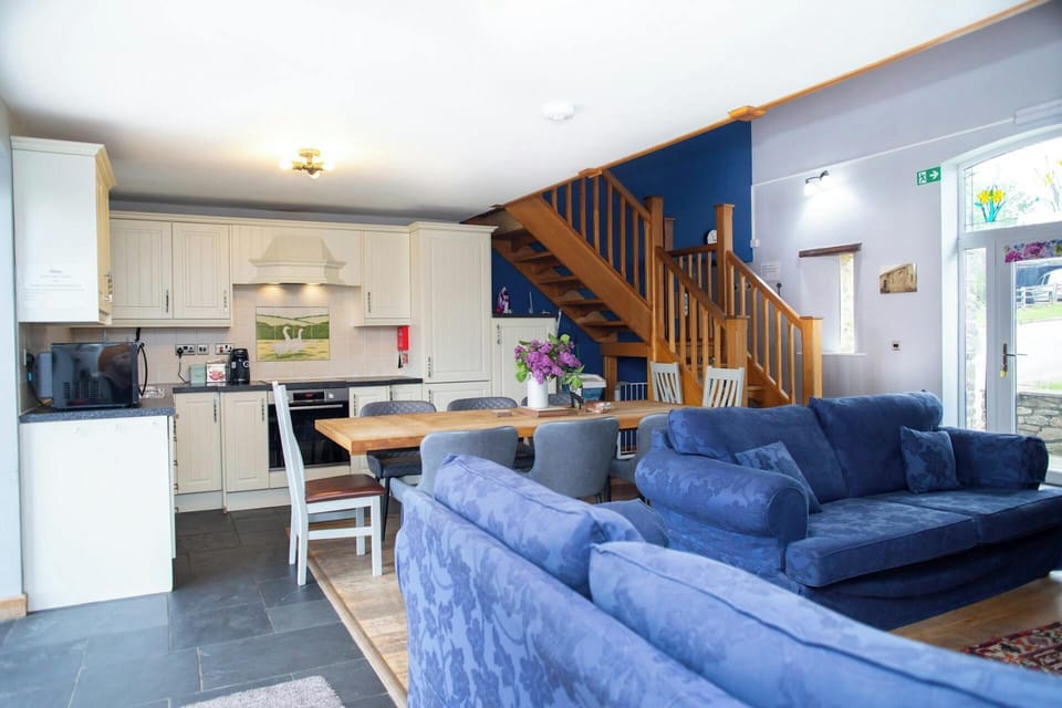 White fitted kitchen with dining table and chairs, viewed from lounge