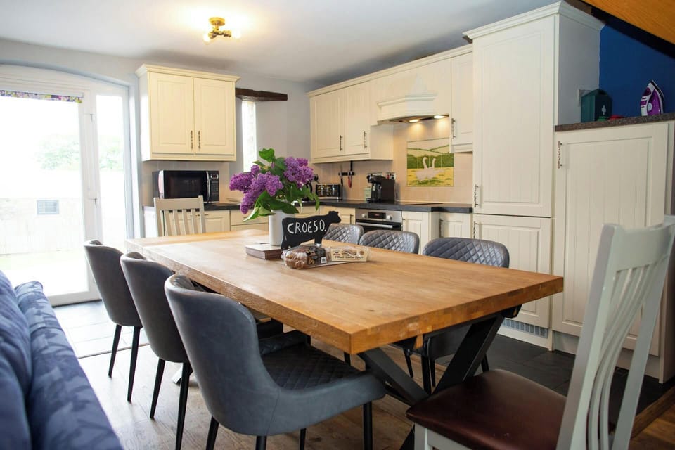 Open-plan kitchen diner with wooden table and upholstered chairs