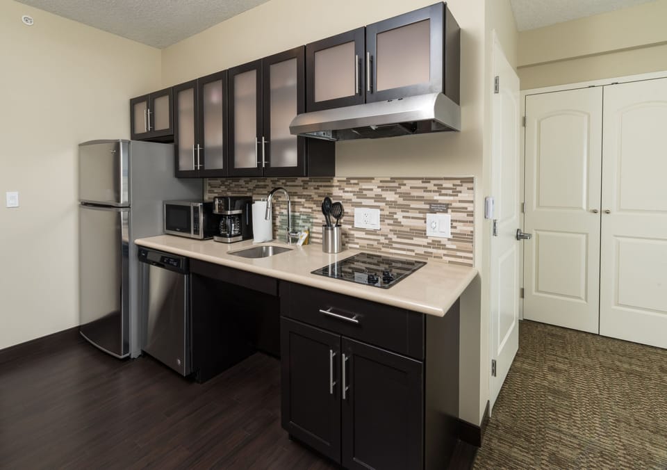 Fully equipped kitchen with stainless steel appliances and stylish cabinetry.