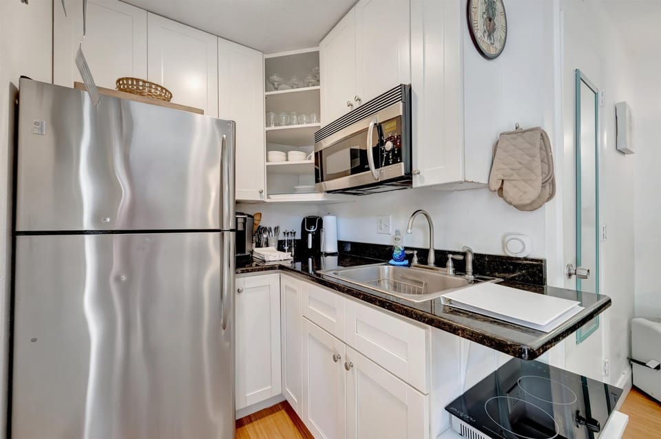 Kitchen with induction cooktop, microwave, and full-size refrigerator