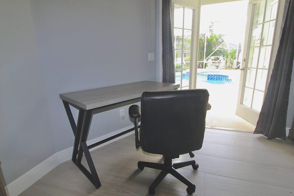 Business travelers can utilize the office space in the Primary Bedroom; work with a poolside view.