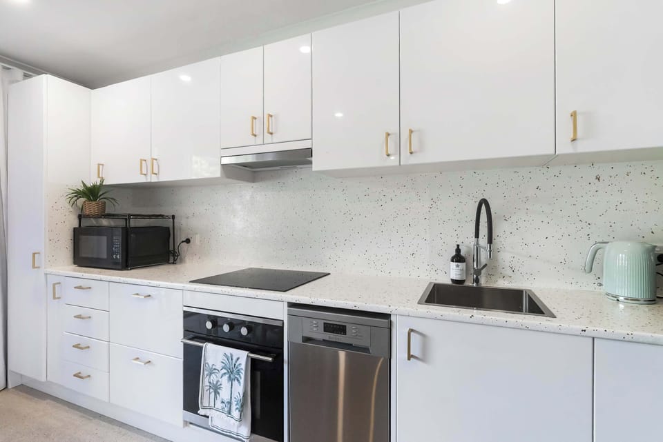 Prepare everything from a quick beachside breakfast to a relaxed evening meal in this bright contemporary kitchen, where sleek finishes and quality appliances make everyday dining effortless.