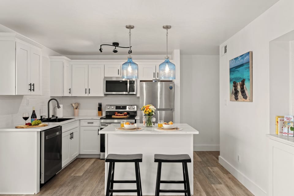 Bright kitchen layout displaying ample shaker cabinetry, a tiled backsplash, and an integrated range microwave.