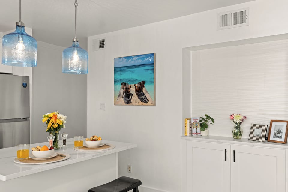 Cozy breakfast bar area featuring stylish blue glass pendant lights and custom built-in cabinetry for extra storage.