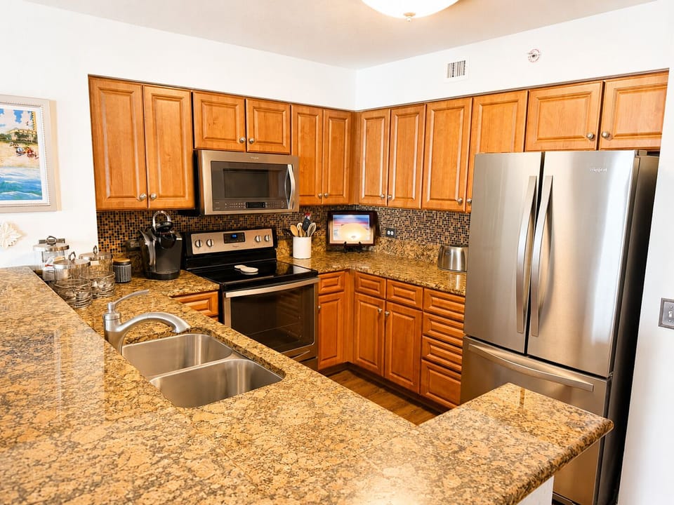 Your fully equipped kitchen features granite countertops, stainless steel appliances, and ample cabinet space—perfect for preparing meals and gathering with loved ones during your stay.