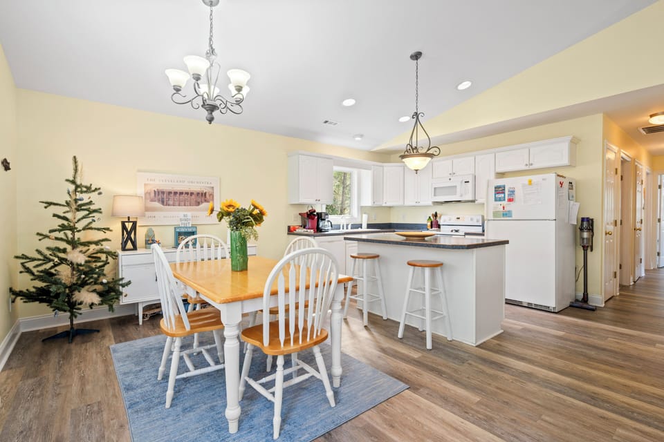 Your bright, open kitchen and dining space welcomes you with warm yellow walls, white cabinetry, and charming farmhouse touches perfect for family meals.