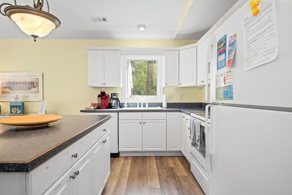 Your fully equipped kitchen invites you to prepare meals with white cabinets, granite counters, and modern appliances.