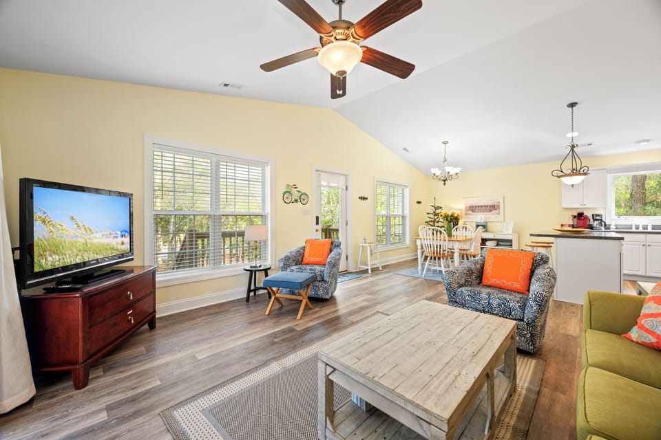 Unwind in your spacious living room where modern comfort meets coastal charm, with a ceiling fan keeping you cool.