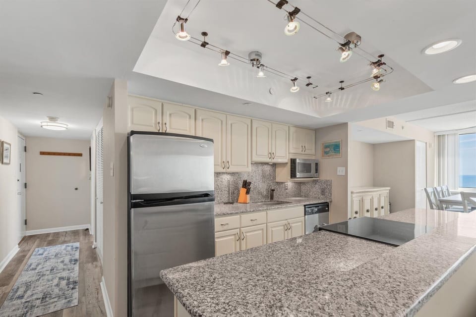 Featuring premium stone countertops, stainless steel appliances, and sleek track lighting to make meal prep a pleasure.