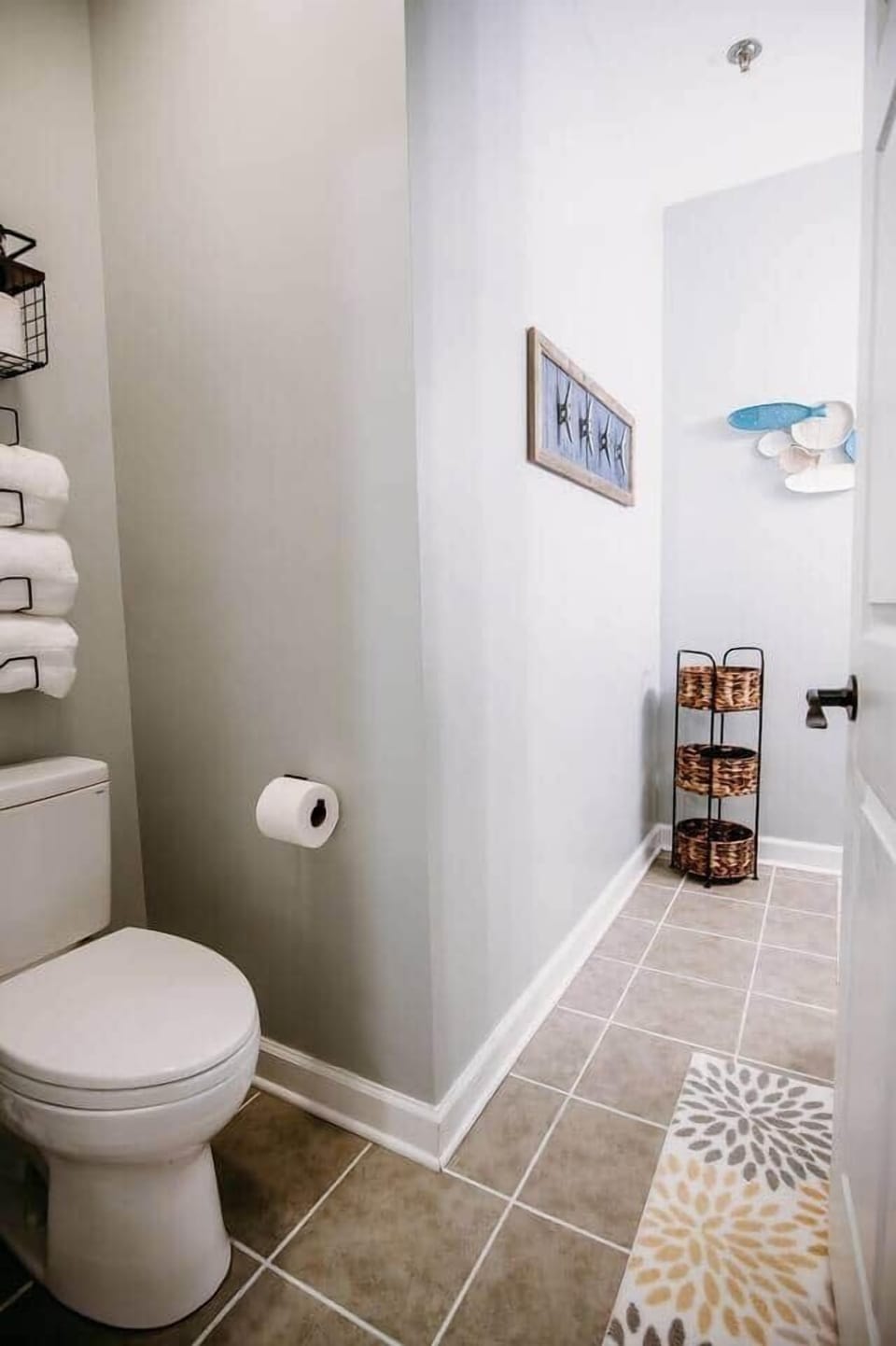 This private full bathroom is conveniently attached to the master bedroom and features a clean, coastal design with a shower/tub combo, soft towels, and plenty of storage space—perfect for families or groups.

