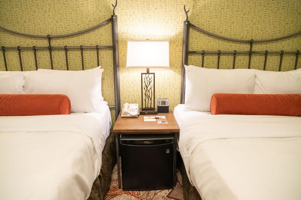 Two double beds with Mountain Luxury bedding — made up fresh each day after your adventures in Banff National Park.