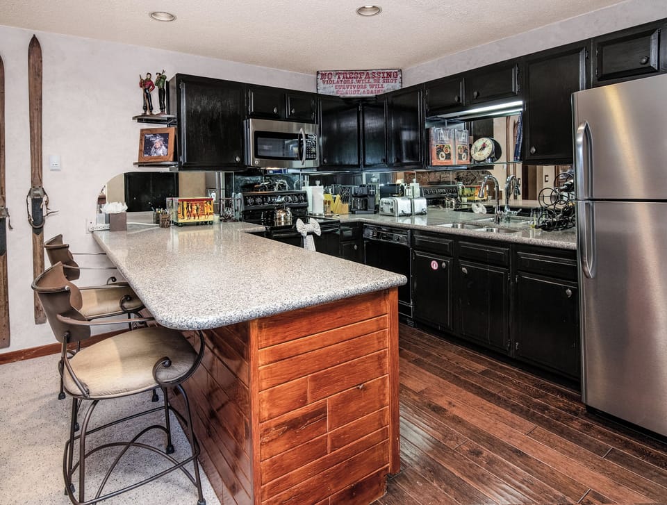 Your fully equipped kitchen features modern stainless appliances, sleek granite counters, and a handy island with seating—perfect for preparing memorable meals and gathering with loved ones during your stay.