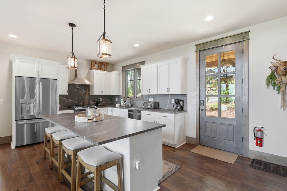 Bright modern kitchen with a large island for seating, sleek finishes, and an open layout that flows effortlessly into the living space — perfect for cooking, gathering, and connecting.