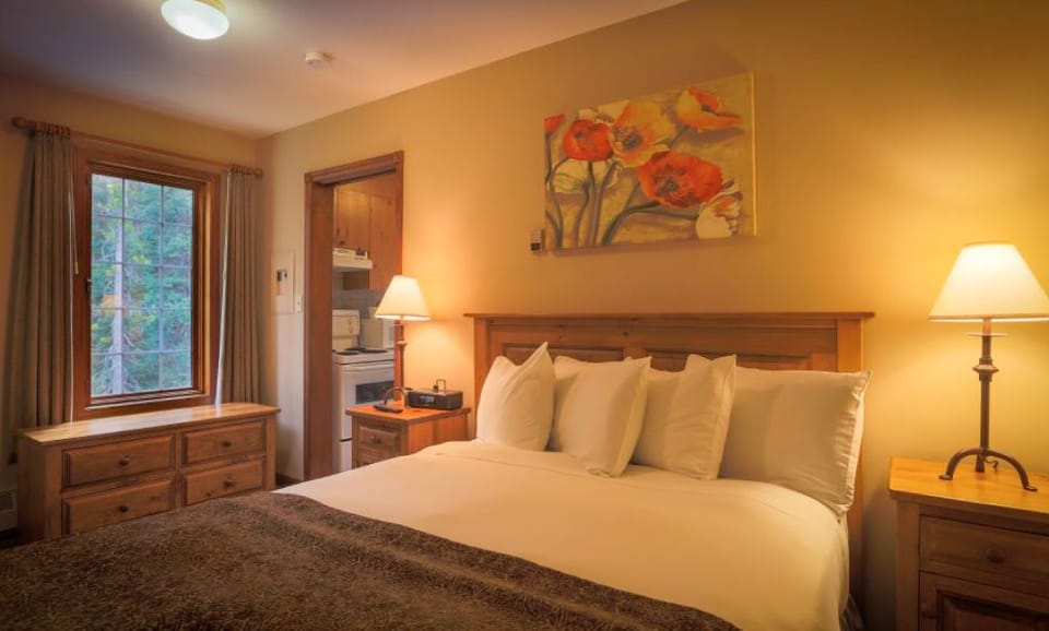Relax in a cozy bedroom featuring a queen-size bed and warm lighting, perfect for restful nights.