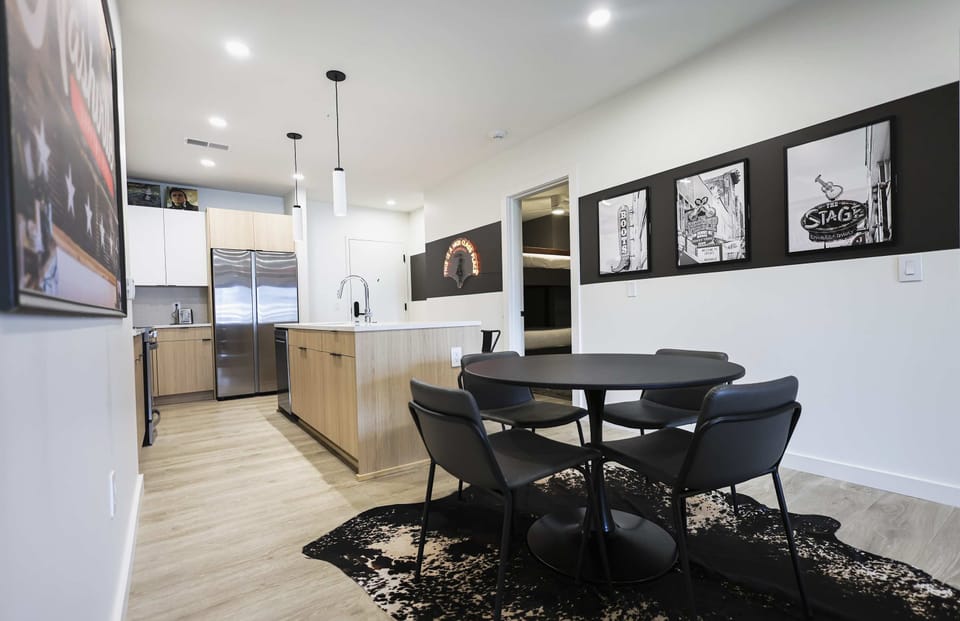 Bright dining space featuring seating for four guests and a fully equipped modern kitchen nearby