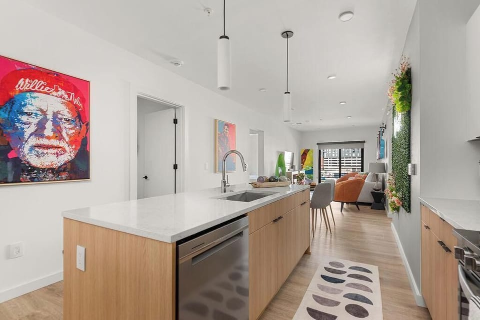 Modern kitchen featuring sleek cabinetry, stainless steel dishwasher, and upscale minimalist design touches
