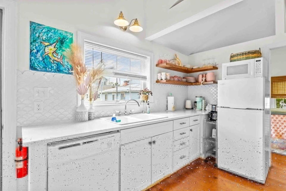 A fully equipped kitchen with beautiful quartz counters and a mermaid accent backsplash! 