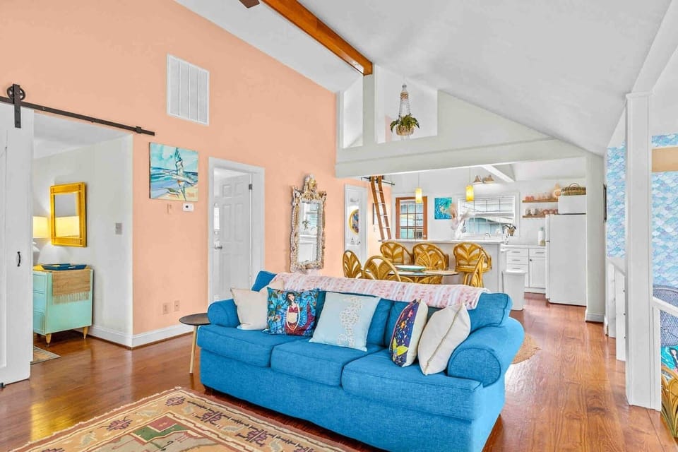 The twin bedroom is to the left of the living room through the barn doors while the queen bedroom is to the right just off the kitchen behind the mermaid scales!