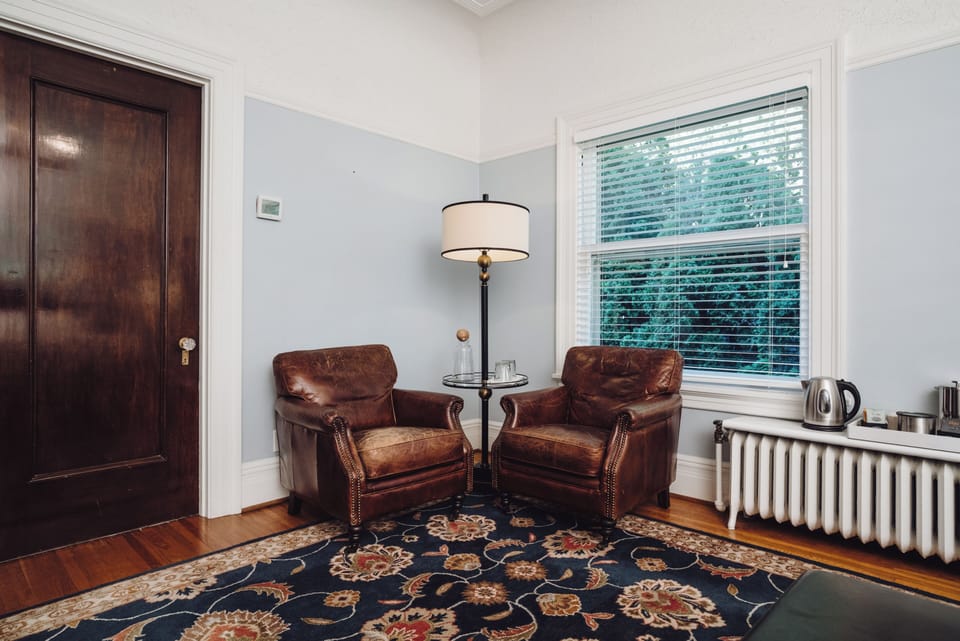 Cozy reading nook with leather chairs, natural light, and classic charm