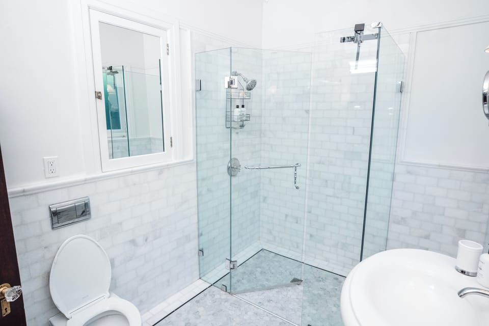 Bright spa-style bathroom with sleek glass shower and elegant marble tile