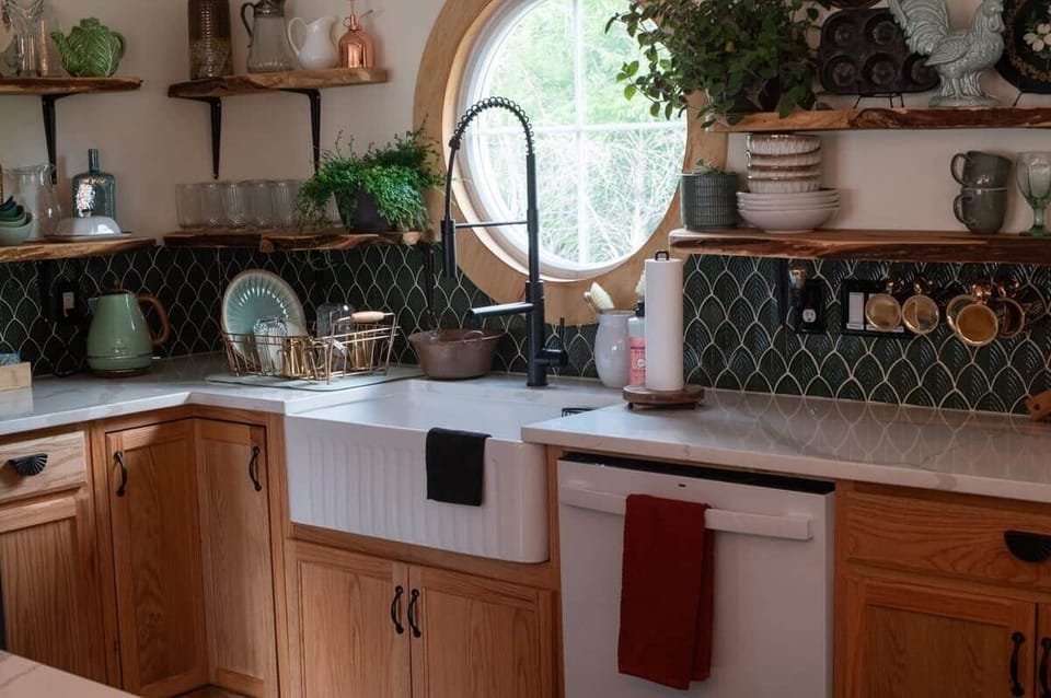 Watch birds, deer, foxes, and frogs roam nearby. Inside, raw cedar shelves float above mermaid-tiled walls. Gilded coffee cups hang near the new dishwasher, stove, and oven, all set against elegant marbleized quartz countertops.