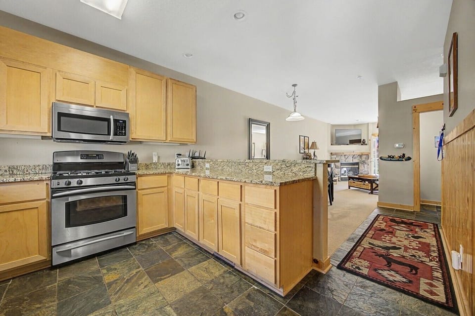 Kitchen view looking toward the half bath, dining area, and living room, with access to the private deck beyond.