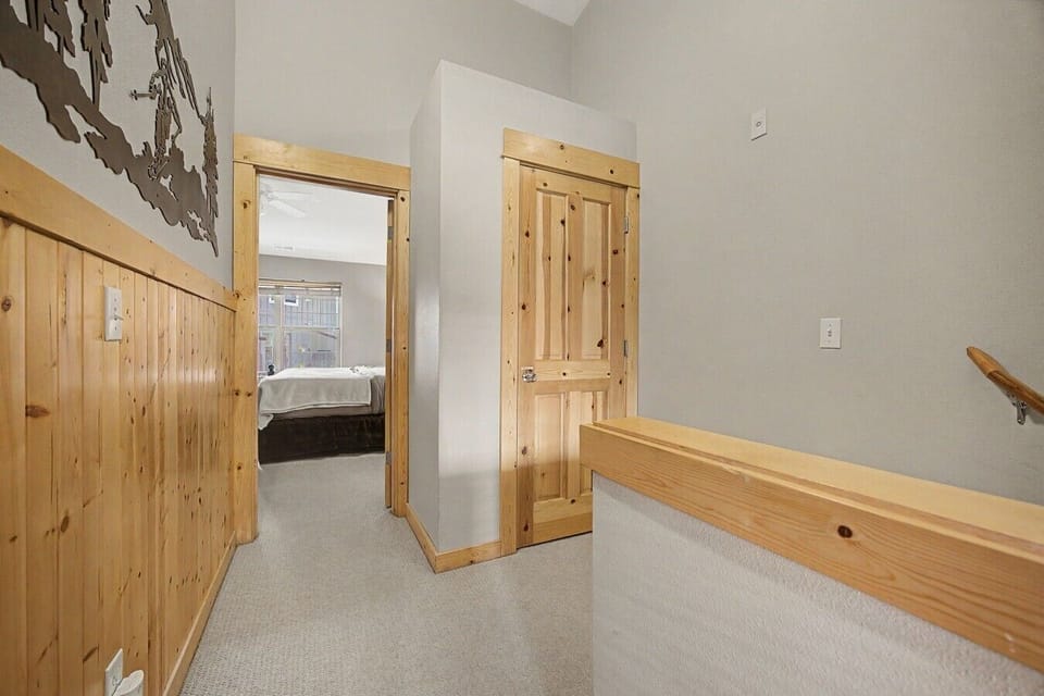 Third-floor hallway leading to the primary bedroom, which features a private en-suite bathroom.