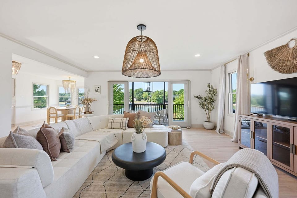 Bright, open living room with large sectional, TV and sliders to deck on the first floor.