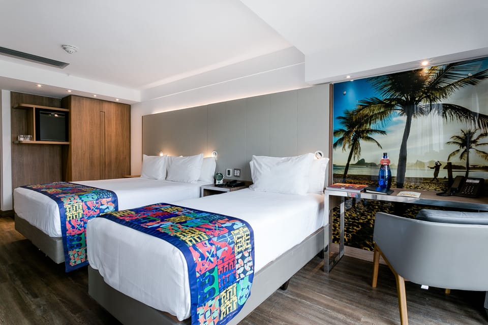 Deluxe Triple Room | Minibar, in-room safe, desk, blackout drapes