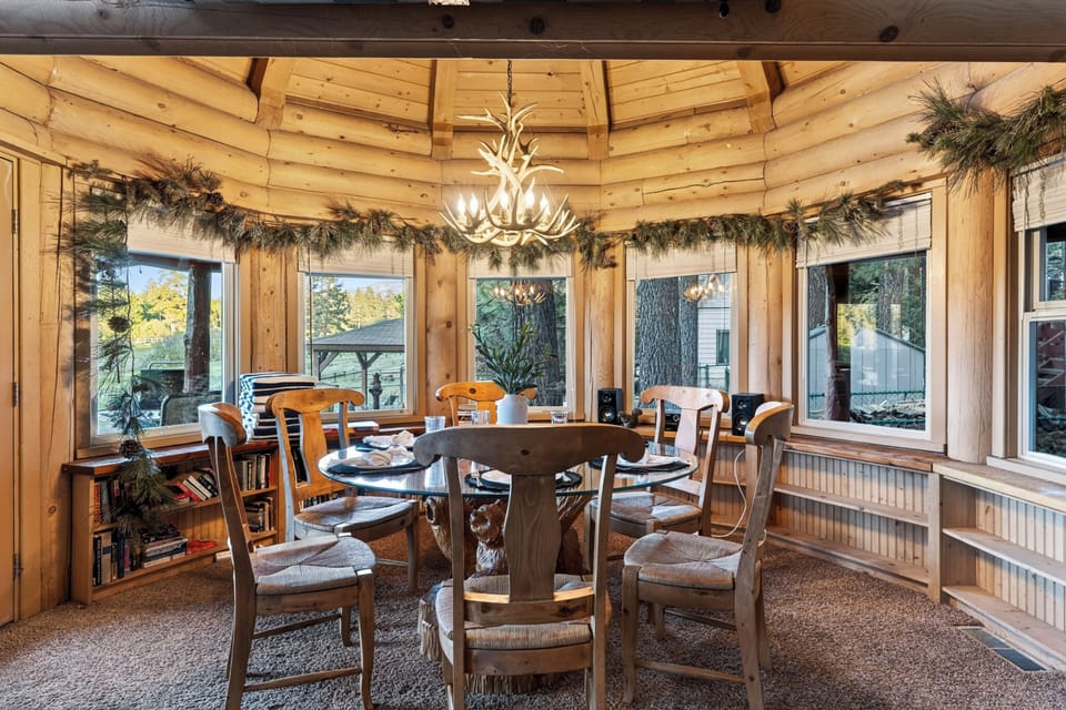 Gather around the table beneath the antler chandelier, with log cabin warmth and scenic fairway views all around.