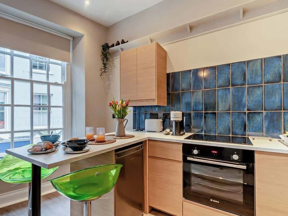 Contemporary kitchen with electric oven and breakfast bar seating.