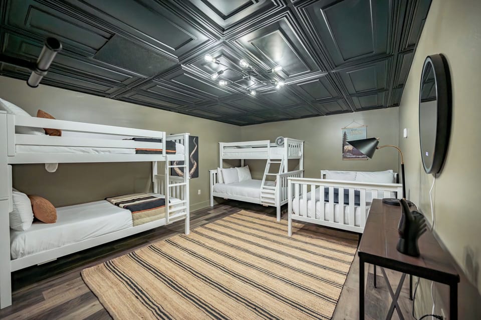 Bed 4 - A sleek and modern bunk room featuring 5 twin beds.