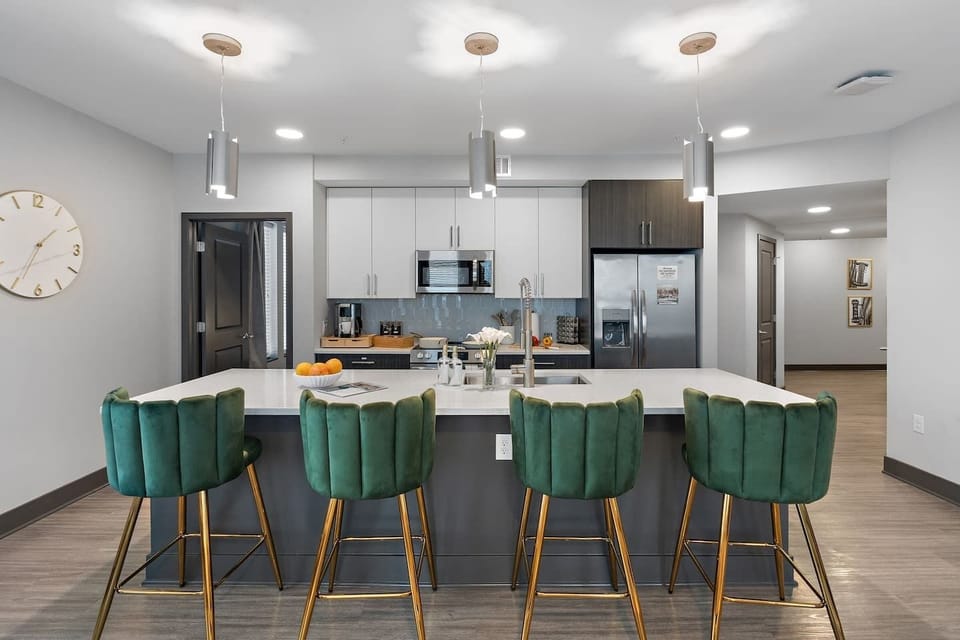 Gather around the oversized island — the heart of this modern kitchen, complete with plush velvet seating and everything you need for a perfect stay.
