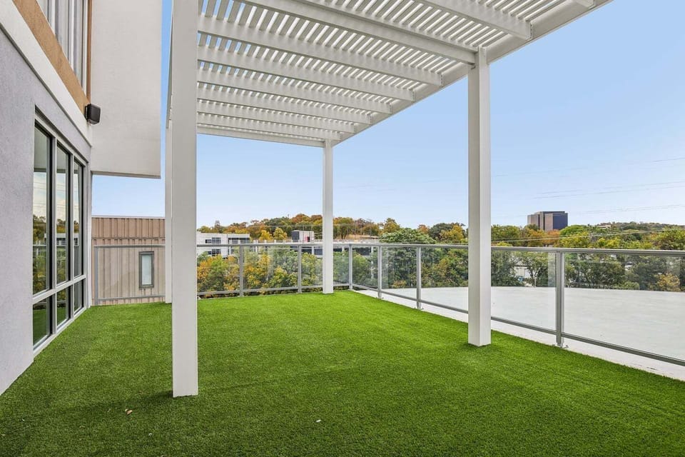 Spacious rooftop terrace with green turf and skyline views—ideal for relaxing, yoga, or catching fresh air between work sessions in Nashville.