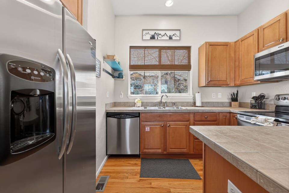 Cook your favorite meals in this fully-equipped kitchen with stainless steel appliances and warm wood cabinets.