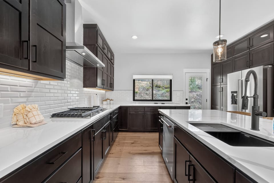 Your fully-equipped kitchen invites culinary creativity with dark wood cabinetry, gleaming marble countertops, and stainless-steel appliances—perfect for preparing meals during your stay.