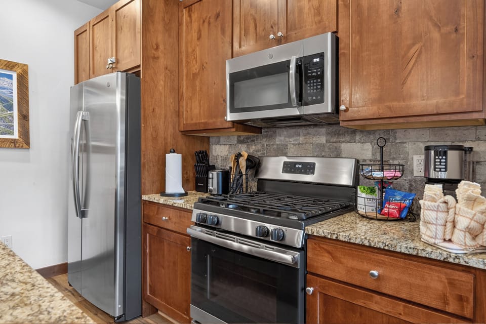 Your fully equipped kitchen features stainless steel appliances and warm wood cabinets, perfect for preparing meals during your stay.
