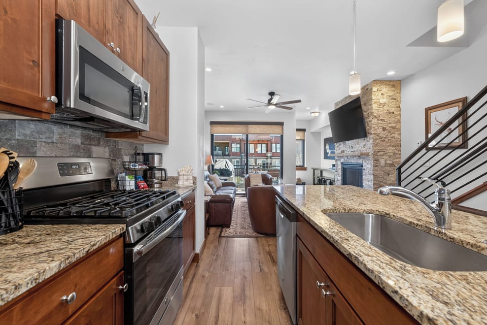 Your gourmet kitchen flows into the open living space, featuring granite counters, stainless appliances, and a cozy stone fireplace.